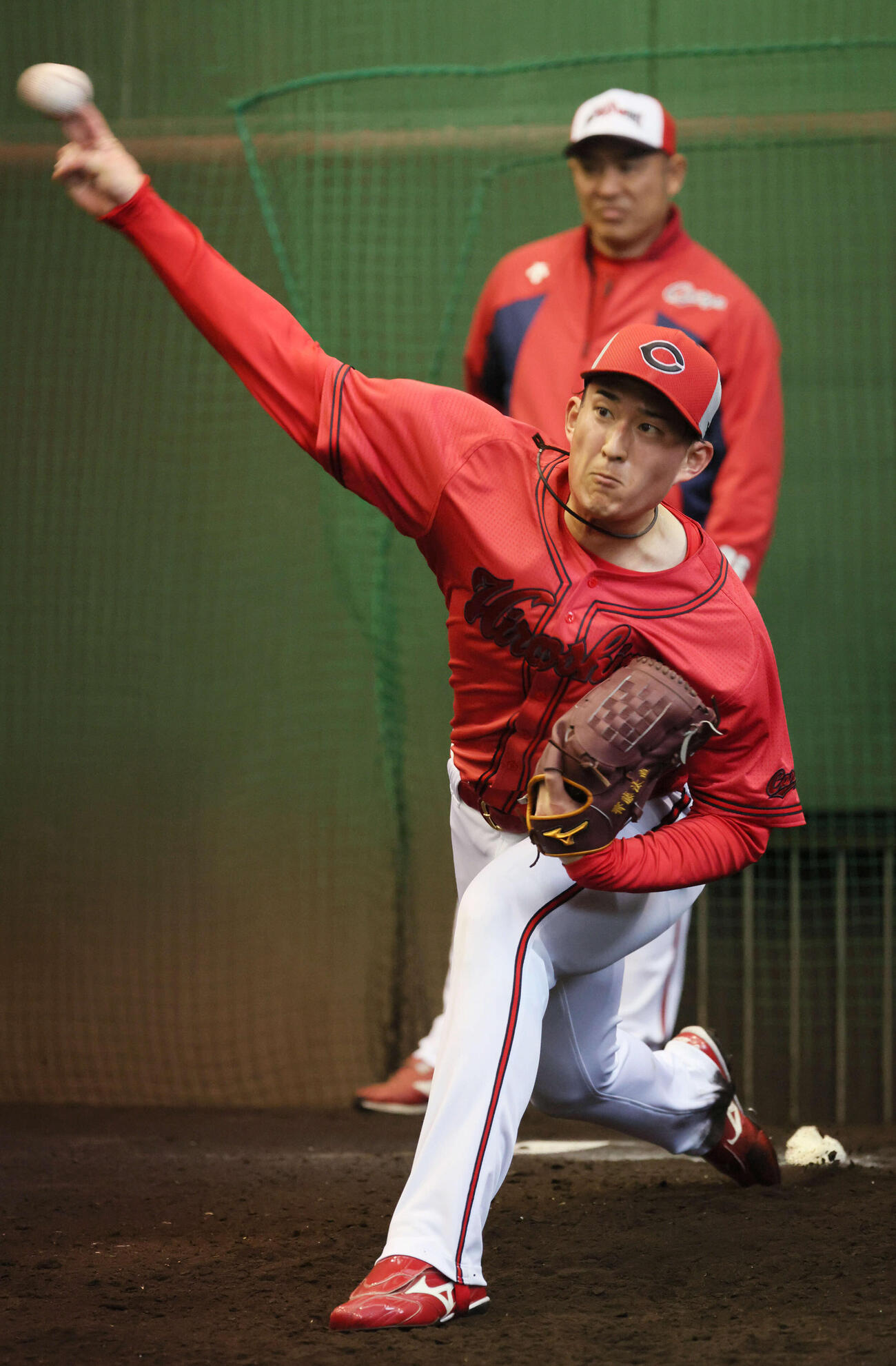 ブルペンで投げる広島ドラフト2位の斉藤汰。後ろは菊地原投手コーチ（撮影・加藤孝規）