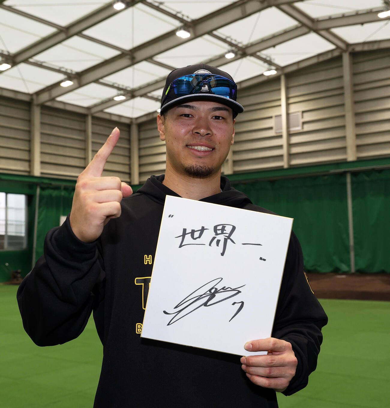 阪神佐藤はWBC侍ジャパンで「世界一」と色紙に記しポーズを決める（撮影・上山淳一）