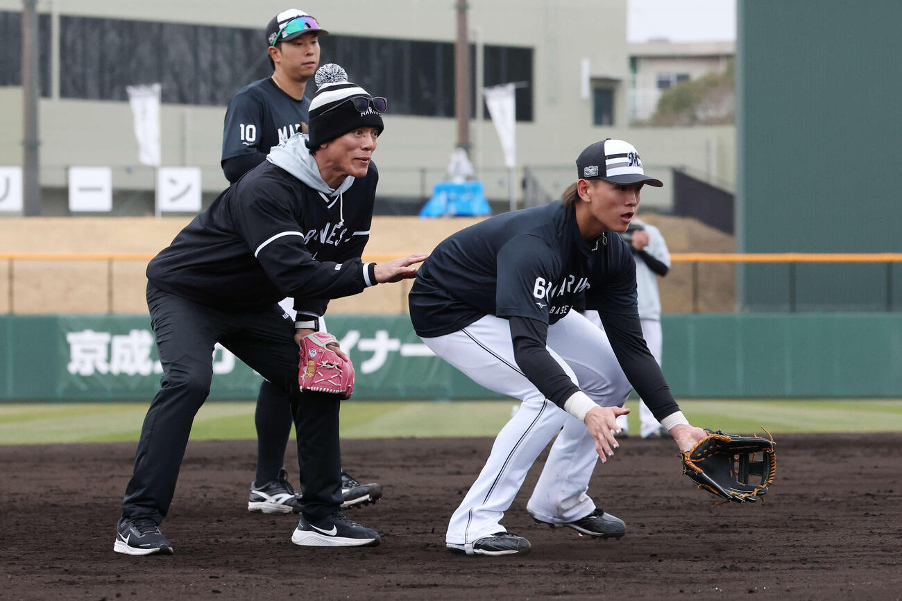 ロッテ山本（右）に守備指導する松井臨時コーチ（撮影・宮地輝）