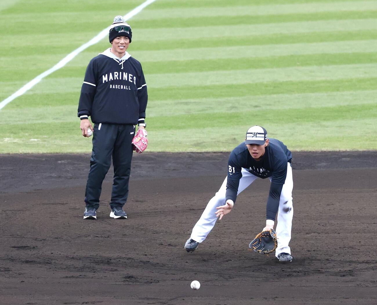 ロッテ山本（右）に守備指導する松井臨時コーチ（撮影・宮地輝）