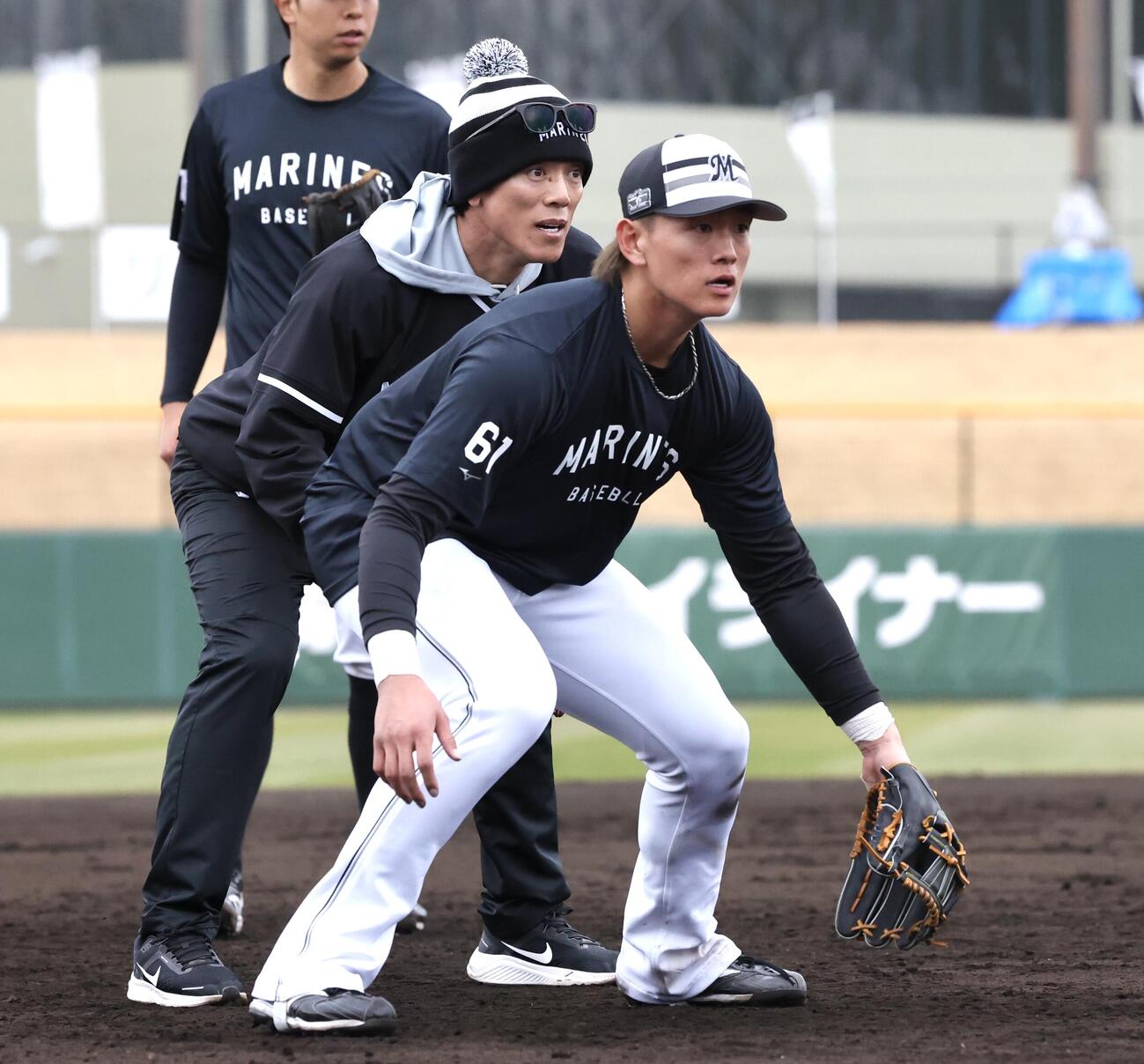 ロッテ山本（手前）に守備指導を行う松井臨時コーチ（撮影・宮地輝）