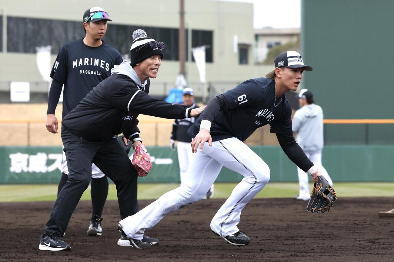 ロッテ山本（右）に守備指導を行う松井臨時コーチ（撮影・宮地輝）