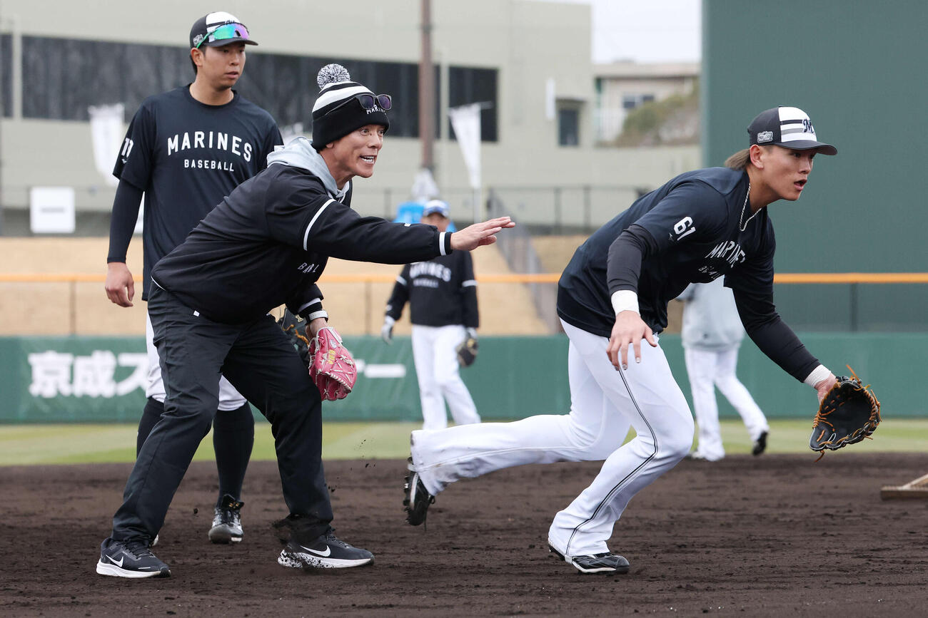 ロッテ山本（右）に守備指導する松井臨時コーチ（撮影・宮地輝）