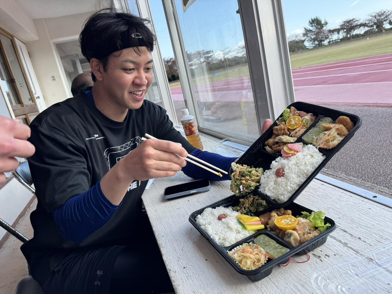 沖縄・今帰仁村の自主トレでおかずのゴーヤチャンプルーをトレードするDeNA平良（撮影・小早川宗一郎）