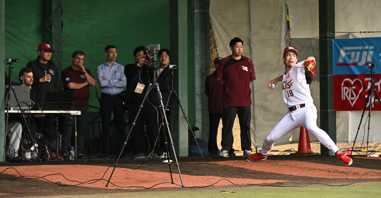ブルペンで投球練習をする楽天前田健。後方左から2人目は三木谷浩史オーナー（撮影・滝沢徹郎）
