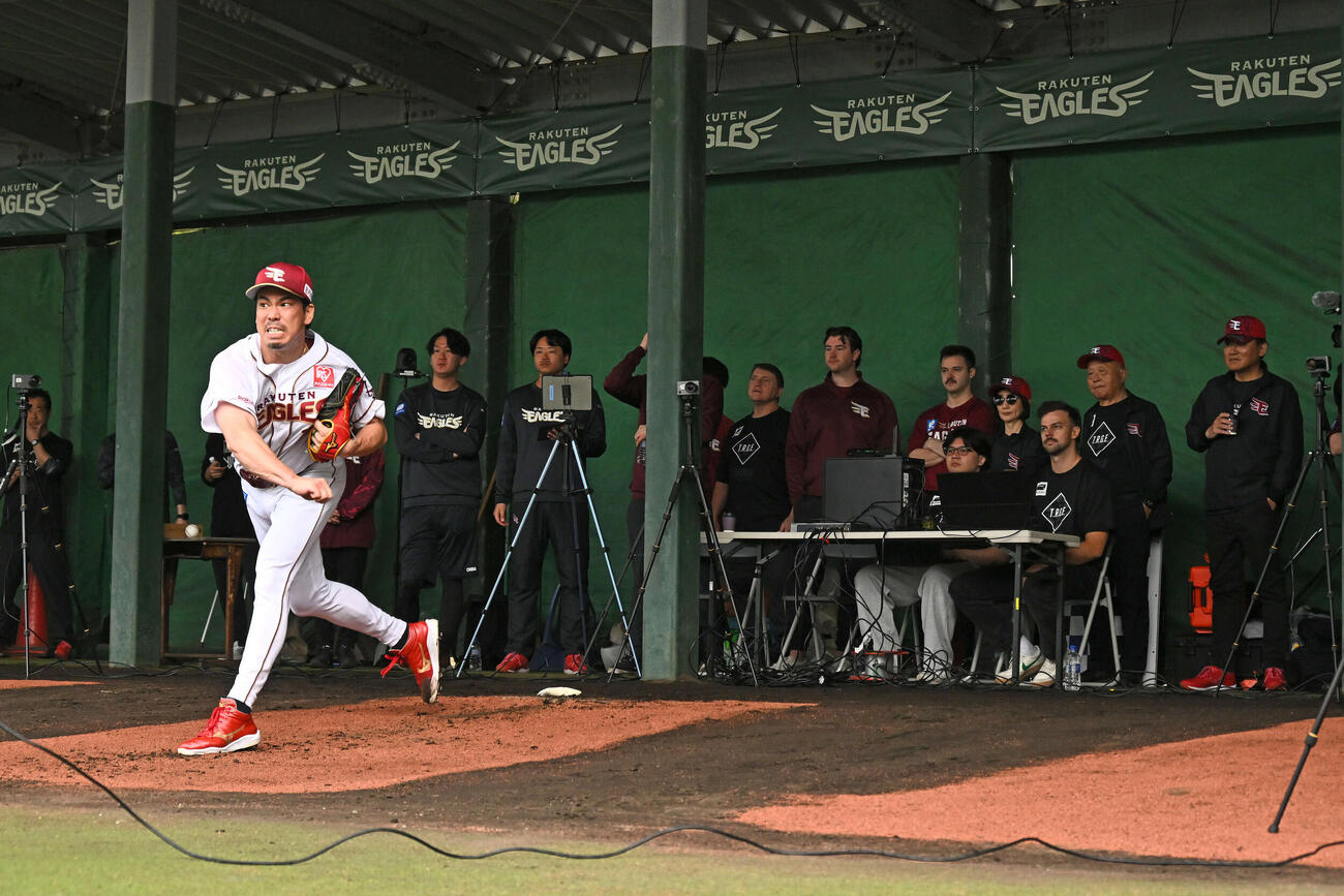ブルペンで投球練習をする楽天前田健。右は見守る三木谷浩史オーナー（撮影・滝沢徹郎）