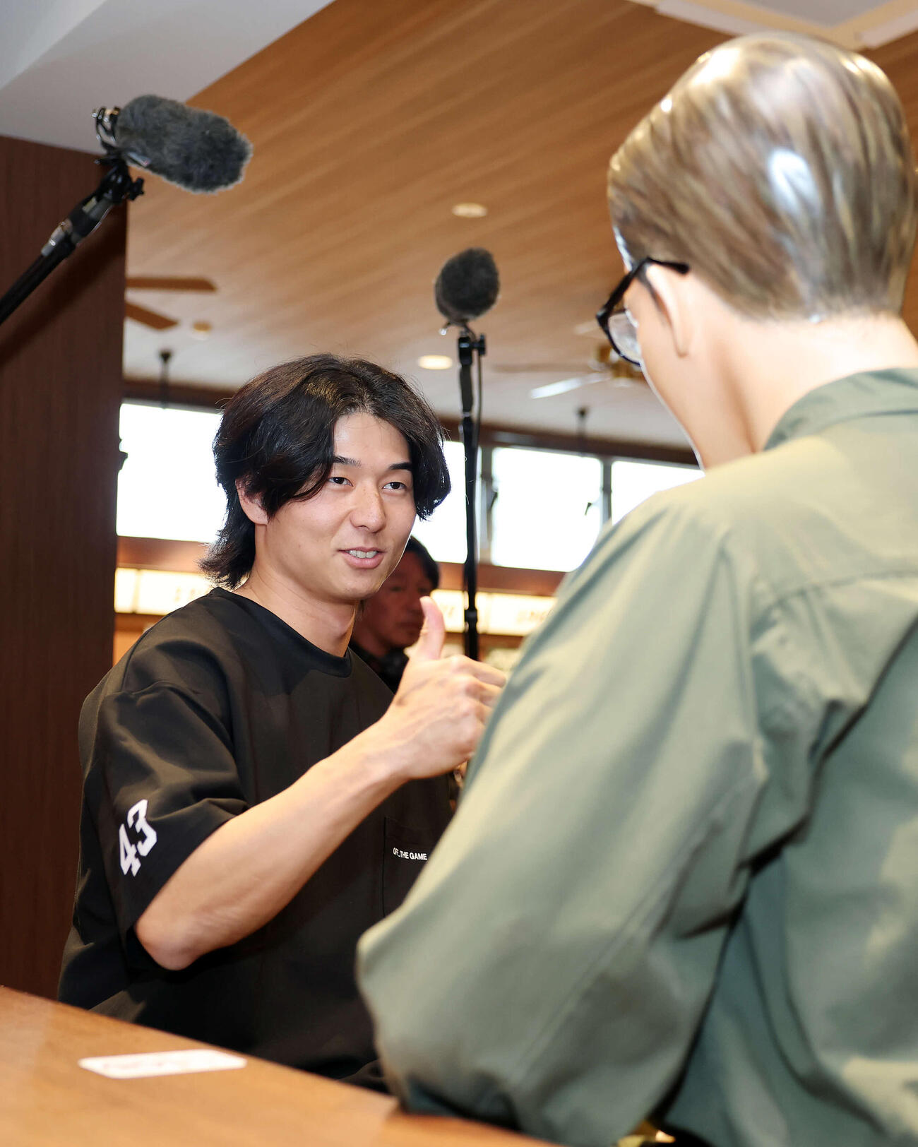 カウンターのジョニーさんにサムズアップするヤクルト増居（撮影・鈴木正人）　