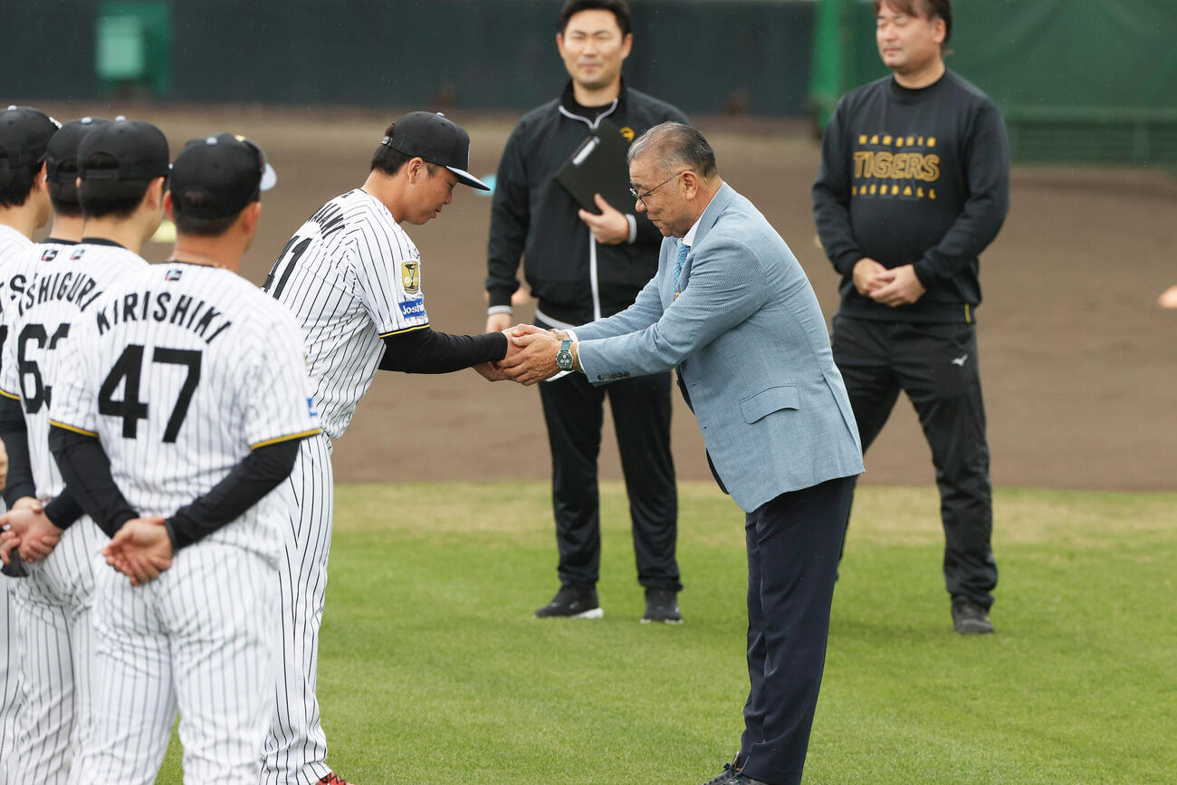 陣中見舞いに訪れた阪神掛布OB会長（右）から目録を贈られる村上（撮影・上山淳一）