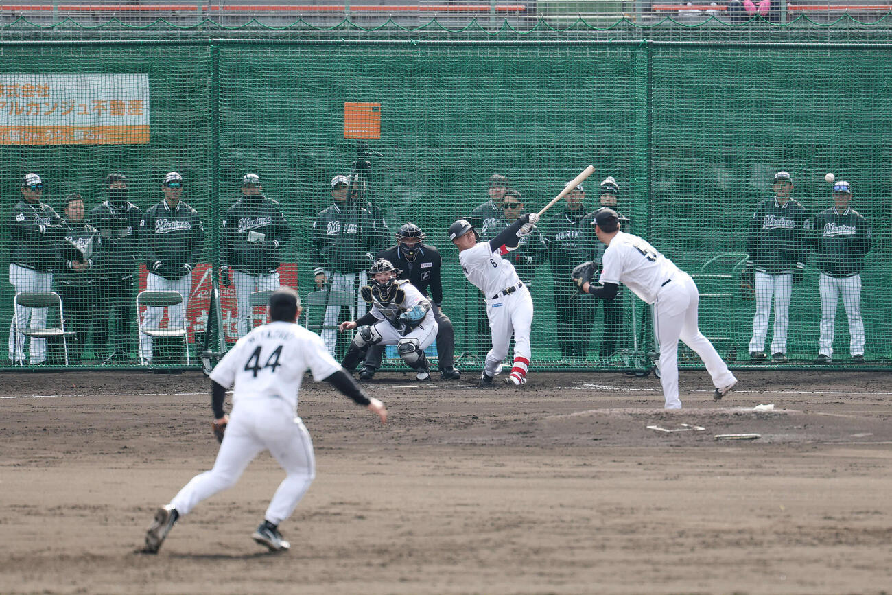 ライブBPでロッテのサブロー監督（左端）が見つめる中、左前打を放つ西川。投手木村（撮影・宮地輝）