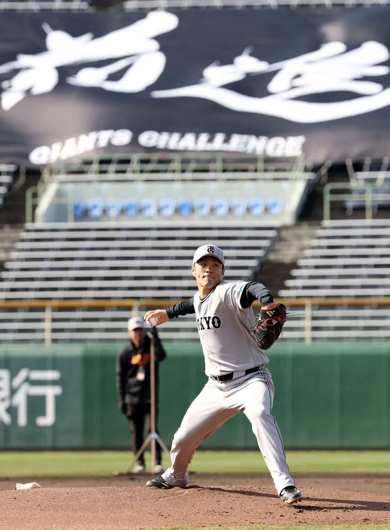 投内連係で「前進」の横断幕を背に投げる巨人則本（撮影・浅見桂子）