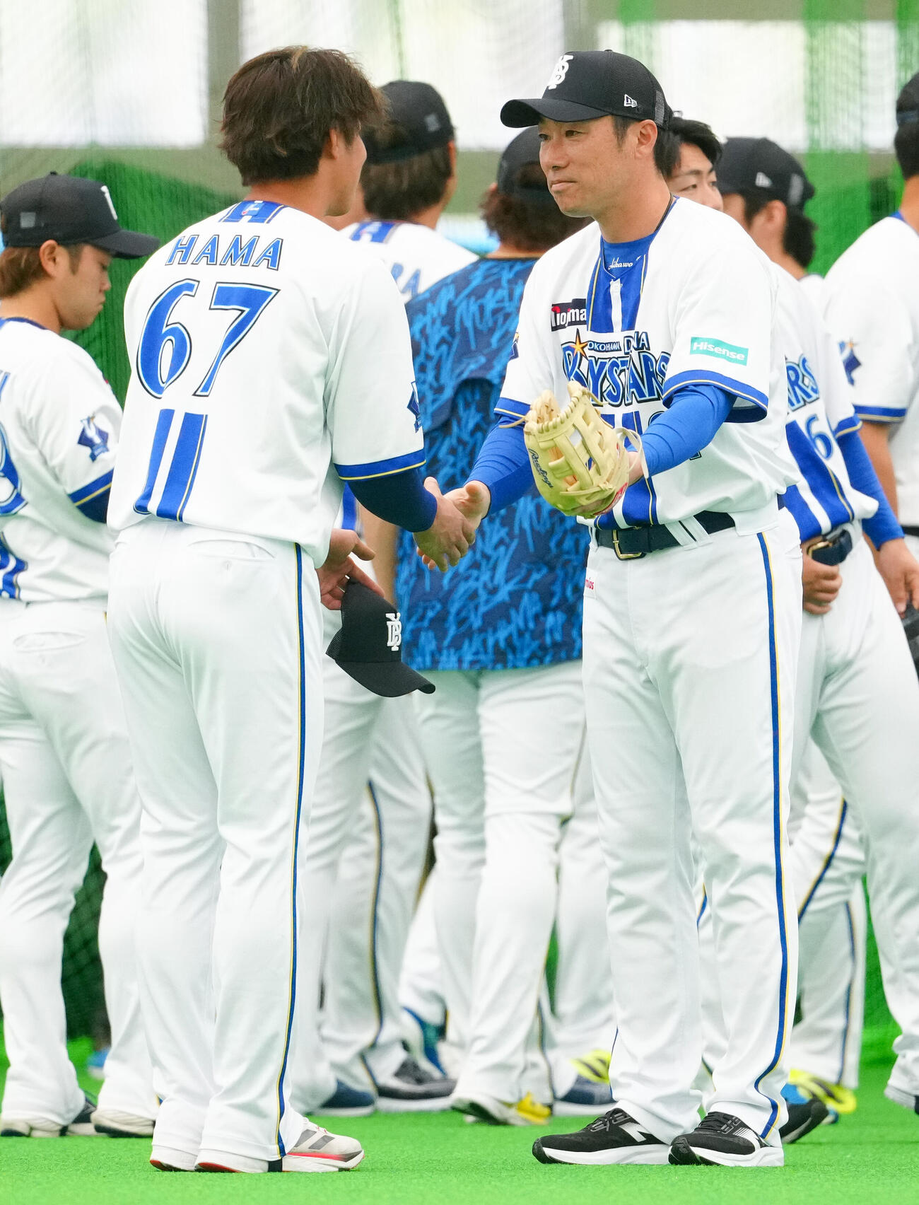 1軍キャンプに合流した浜（手前左）と握手を交わすDeNA相川監督（撮影・鈴木みどり）