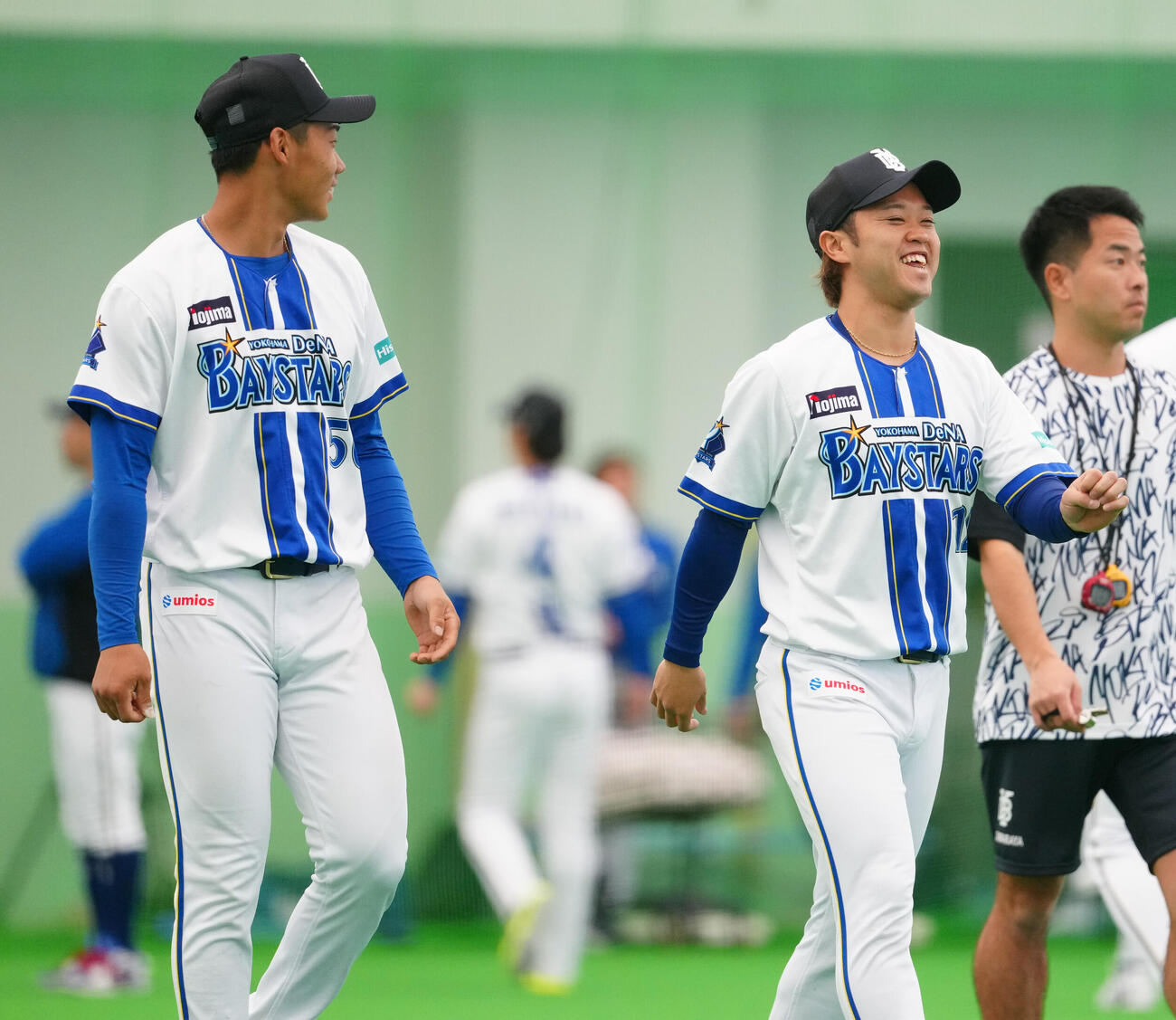 1軍キャンプに合流したDeNA西巻（右手前）は田内と笑顔で話す（撮影・鈴木みどり）