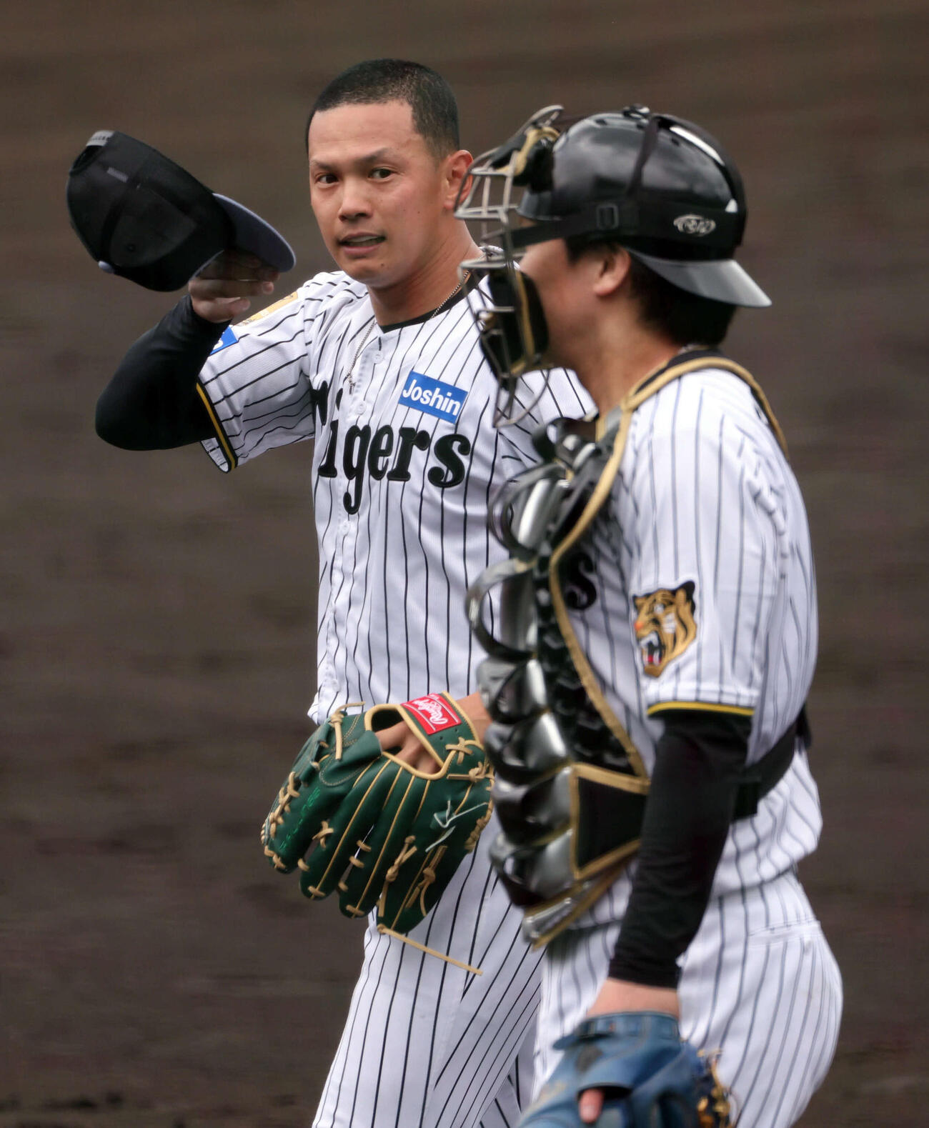 シート打撃登板を終えた阪神能登は捕手の伏見と話しながら引き揚げる（撮影・西尾就之）