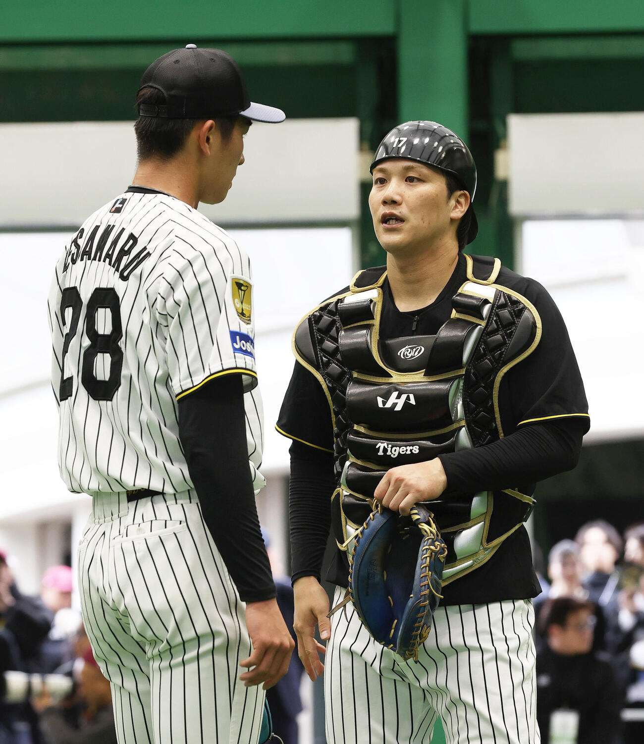 ブルペンで投球終えた阪神今朝丸（左）と話す伏見（撮影・上山淳一）