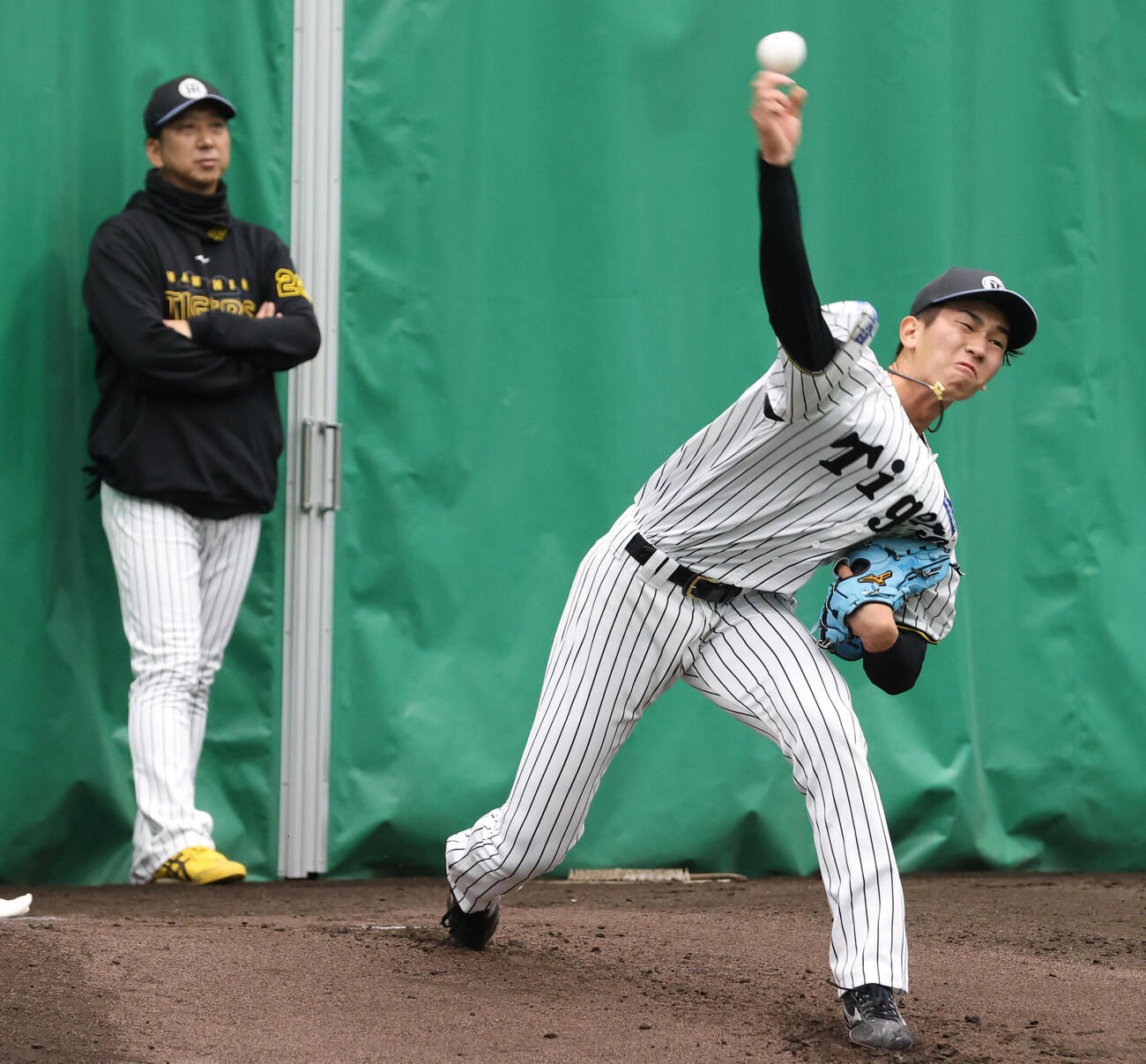 ブルペンで投球する阪神今朝丸。左は藤川監督（撮影・上山淳一）