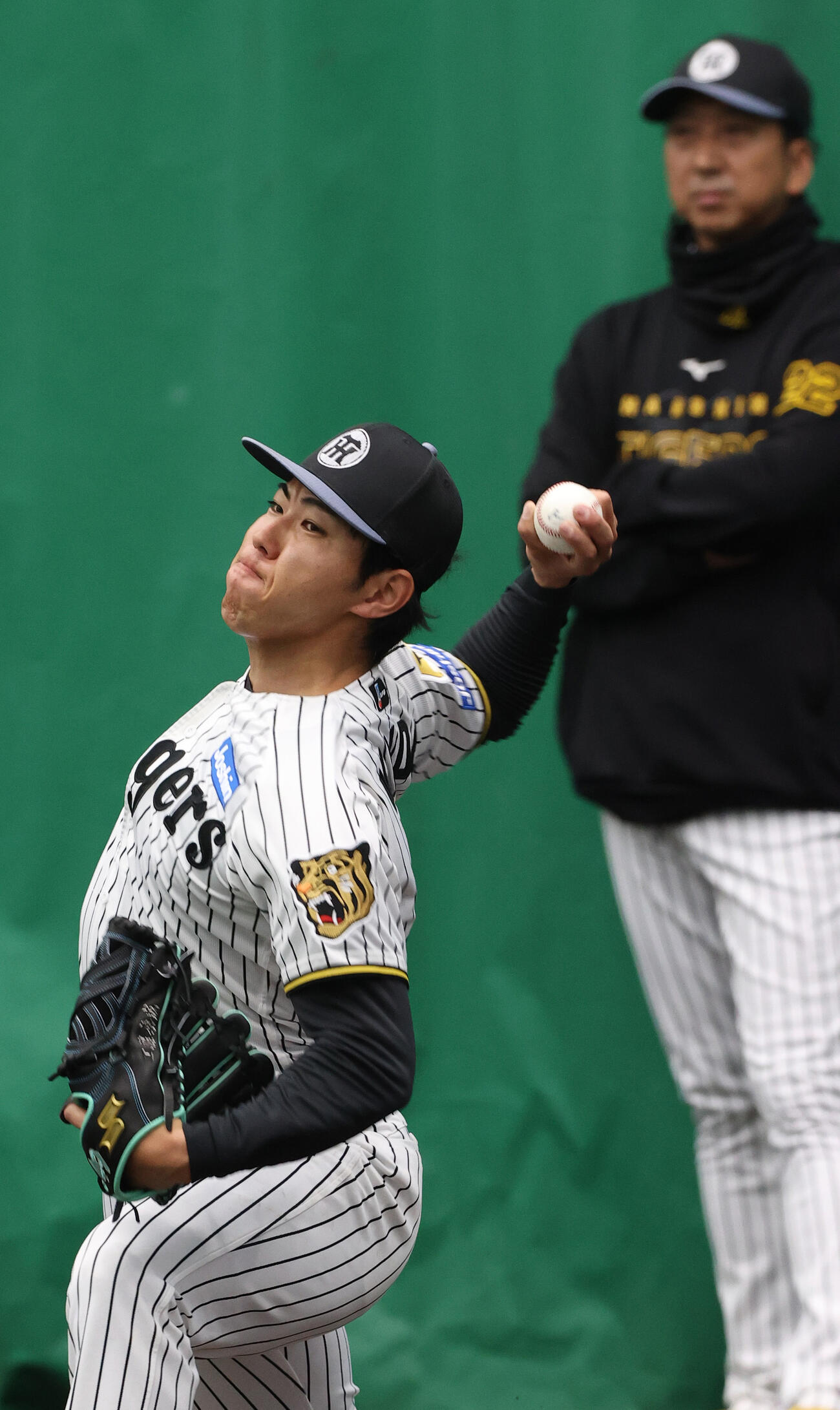ブルペンで投球する阪神工藤。奥は阪神藤川監督（撮影・上山淳一）