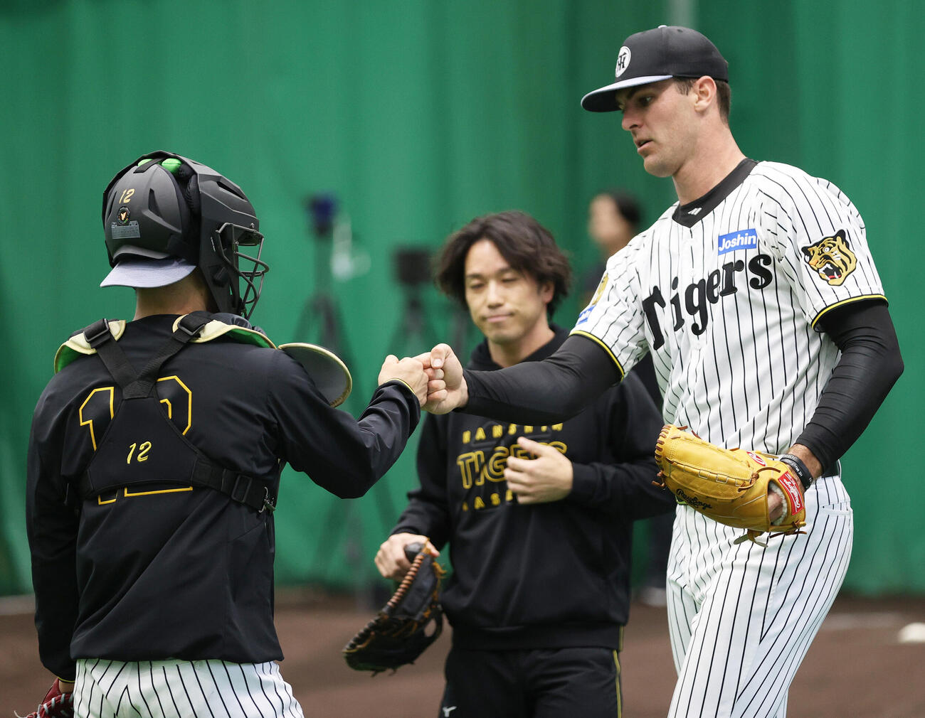 ブルペンで投球を終えた阪神ラグズデール（右）は坂本とタッチをかわす（撮影・上山淳一）
