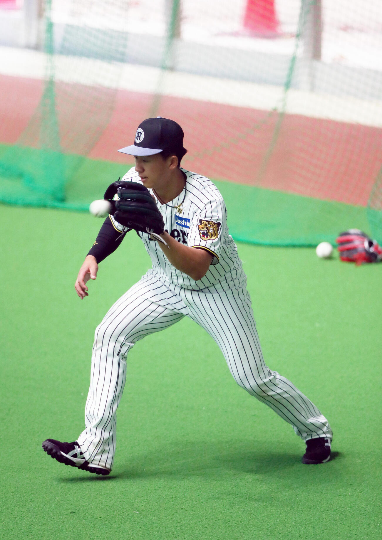 具志川の室内でノックを受ける阪神立石（撮影・上山淳一）