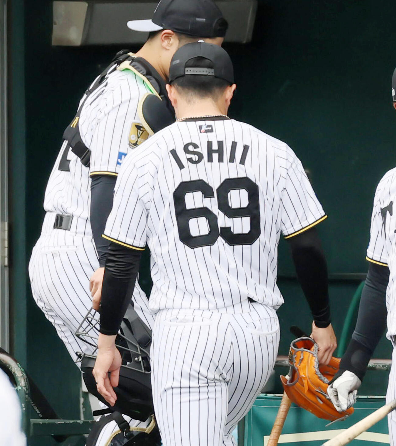 シート打撃練習で装着していたピッチコムの機械を右手で持つ阪神石井（撮影・加藤哉）