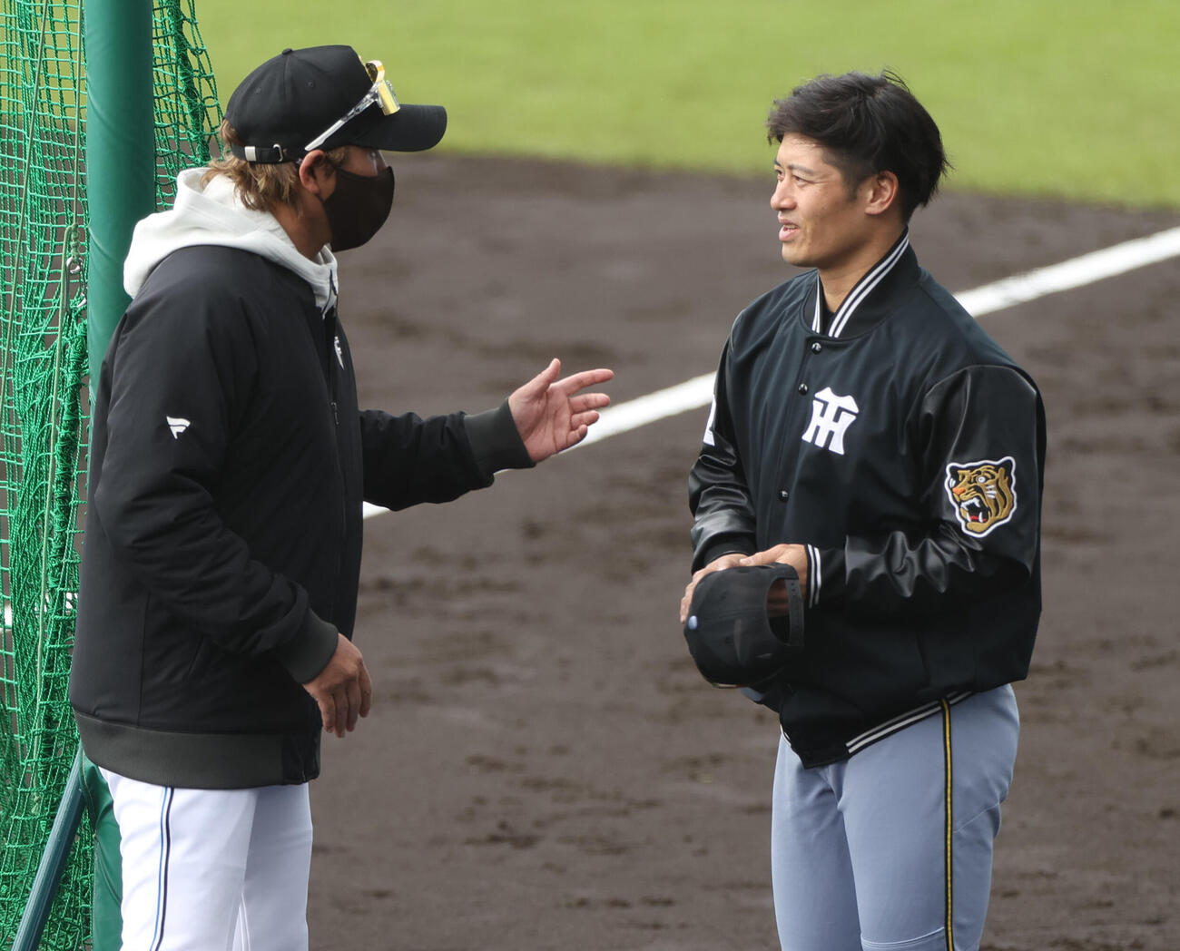 練習試合・日本ハム対阪神　試合前、日本ハム新庄監督（左）と話す阪神坂本（撮影・上山淳一）