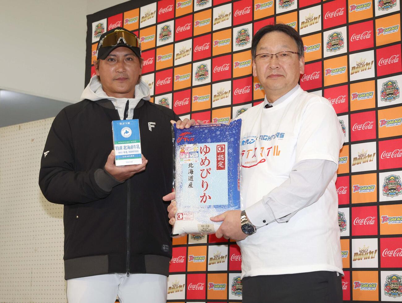 道産農畜産物贈呈式で牛乳と米をホクレン農業協同組合連合会徳田代表理事副会長から贈られる新庄監督（撮影・黒川智章）