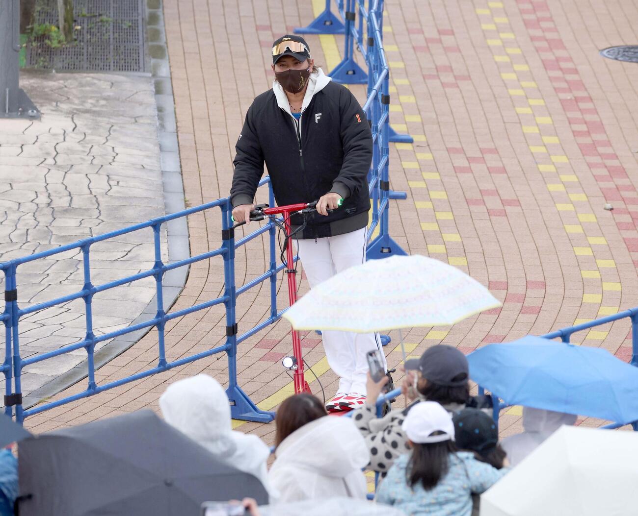 雨の中、球場入りする新庄監督（撮影・黒川智章）