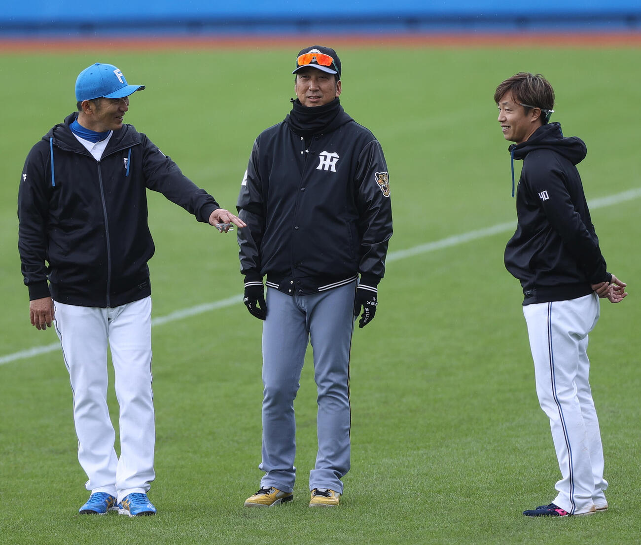 練習試合・日本ハム対阪神　試合前、阪神藤川監督（中央）と話す日本ハム島本。左は日本ハム山田バッテリーコーチ（撮影・上山淳一）