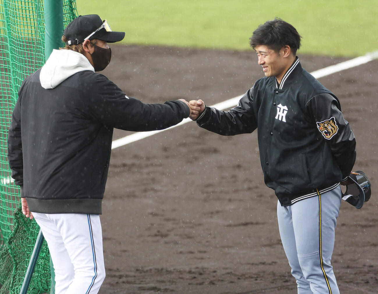 練習試合・日本ハム対阪神　試合前、阪神坂本（右）は日本ハム新庄監督と話を終えグータッチする（撮影・上山淳一）