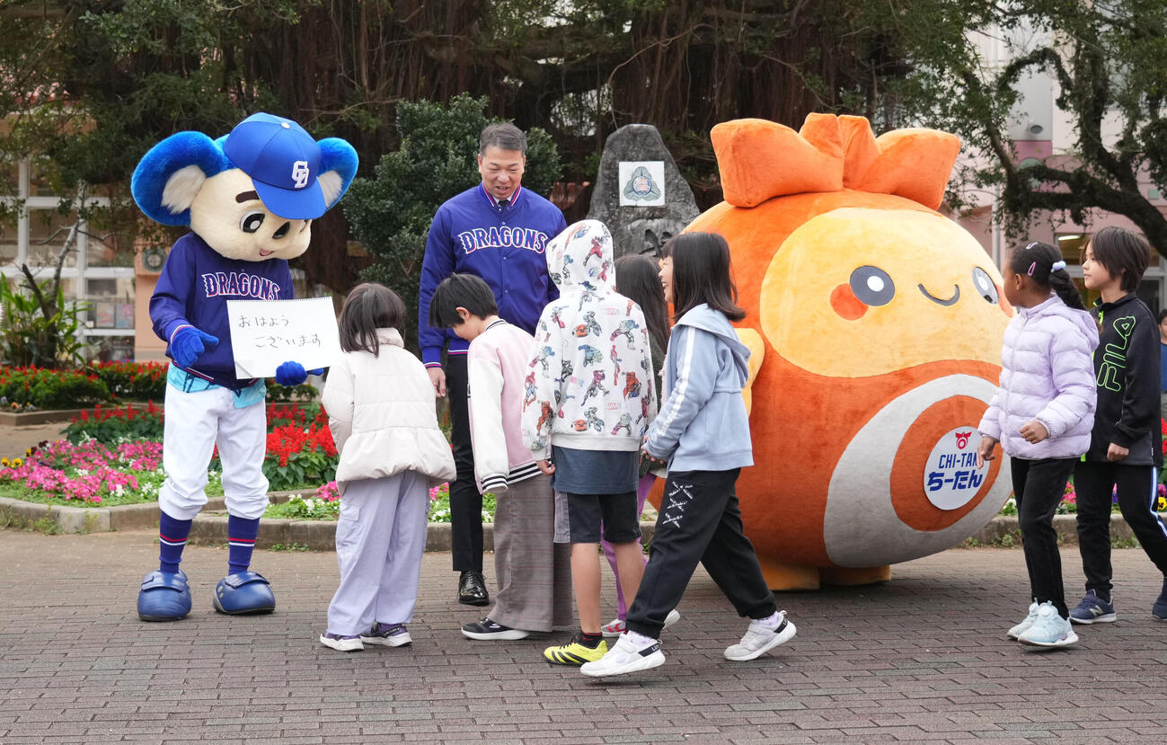 キャンプ地の小学校を訪れあいさつ運動を行う奥・左からドアラ、北谷町の渡久地町長、ちーたん（撮影・森本幸一）