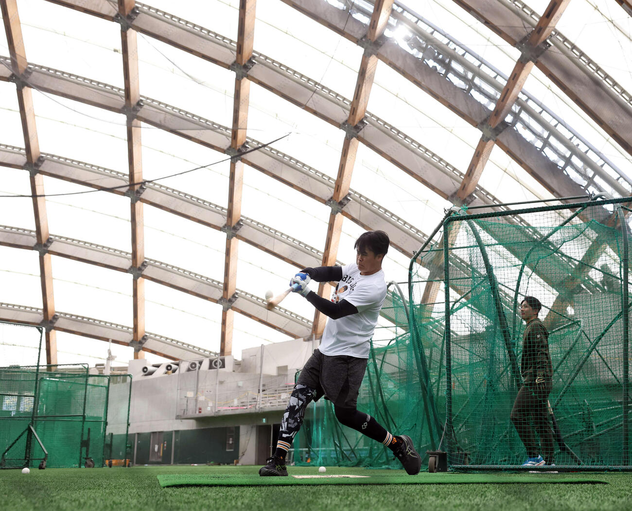 休日返上で木の花ドームに練習に来た巨人中山（手前）と泉口はマシン打撃で打ち込む（撮影・浅見桂子）