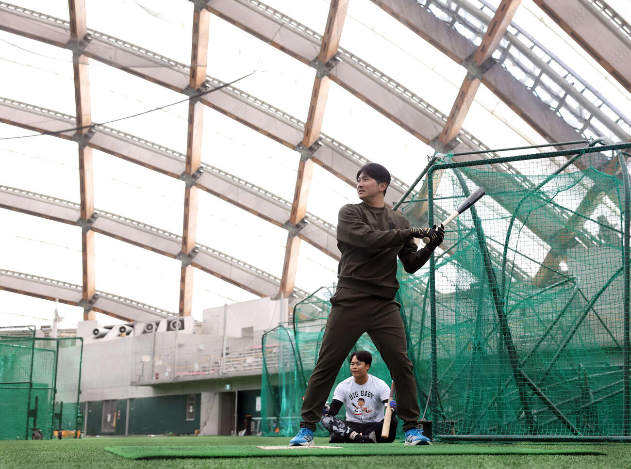 休日返上で木の花ドームに練習に来た巨人泉口（手前）と中山はマシン打撃で打ち込む（撮影・浅見桂子）