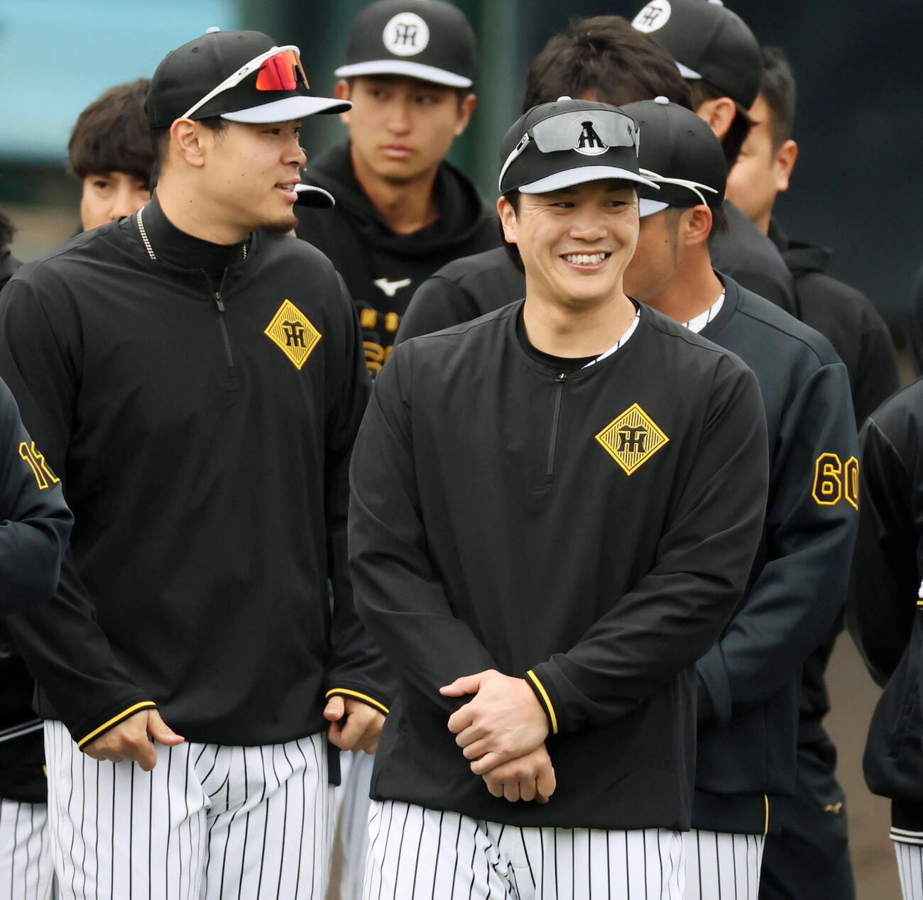 朝のミーティングで笑顔を見せる阪神伏見。左は佐藤（撮影・加藤哉）