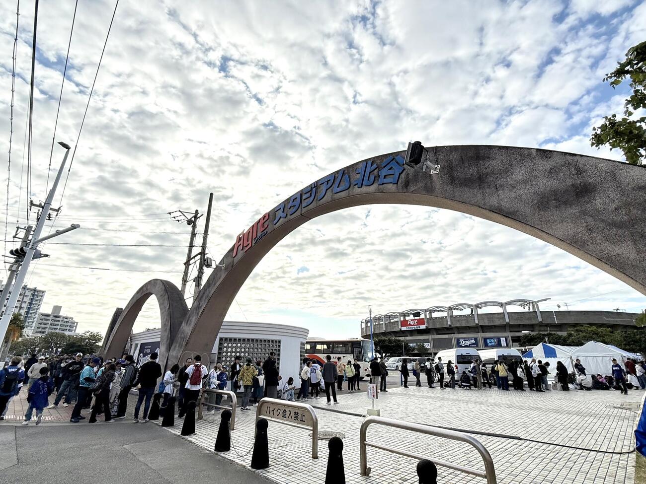 中日北谷キャンプ地で午前10時からのグッズ販売を待つ、ファンたち。開店1時間前には右端のテントを先頭に左端の歩道にまで列が続く（撮影・中島麗）