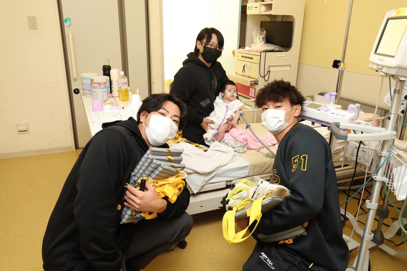 入院患者の児童と記念撮影する阪神工藤（左）と早川