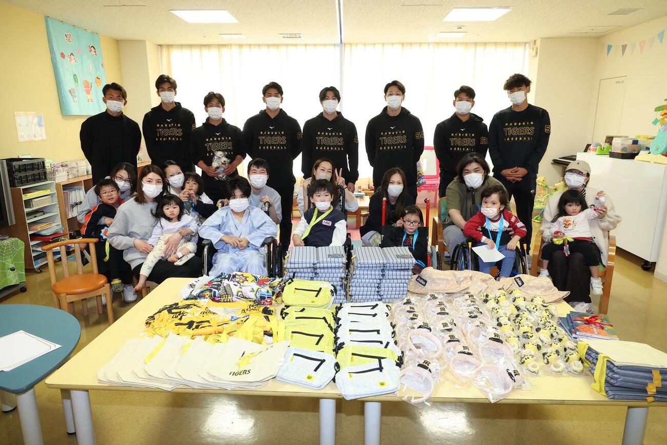 入院患者の児童と記念撮影する鳥谷氏（左）と阪神の選手ら。左2人目から今朝丸、伊原、岡留、工藤、木下、嶋村、早川