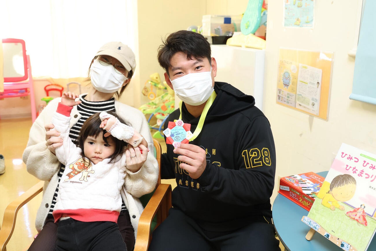 病院を訪問し、患者と家族と写真を撮る阪神嶋村