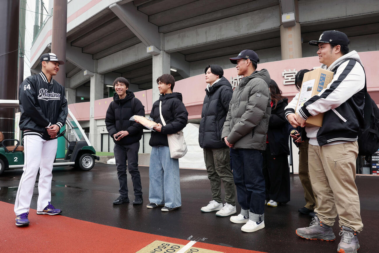 母校東海大九州農学部の学生が生産製造した加工食品や農作物を進呈され交流するロッテ広池（撮影・宮地輝）