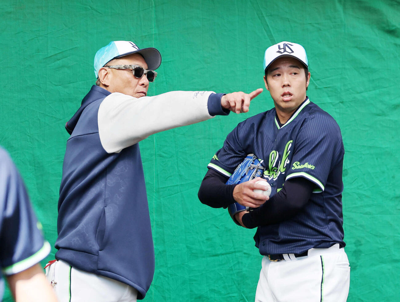 ブルペンで投球練習中、会話するヤクルト池山監督（左）と青柳（撮影・鈴木正人）　