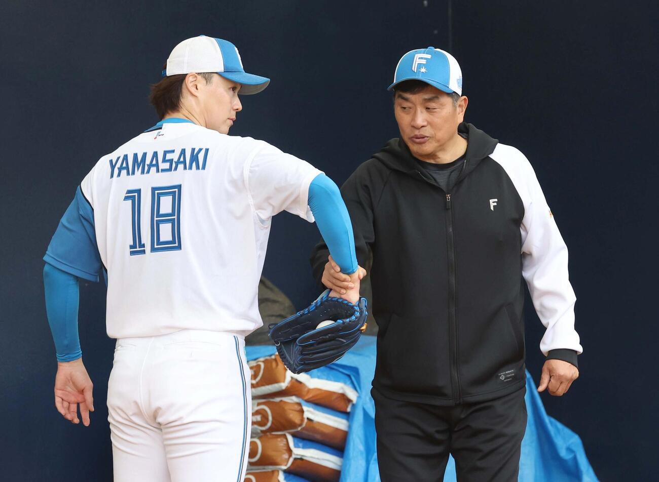 山崎を指導する山本臨時投手コーチ（撮影・黒川智章）