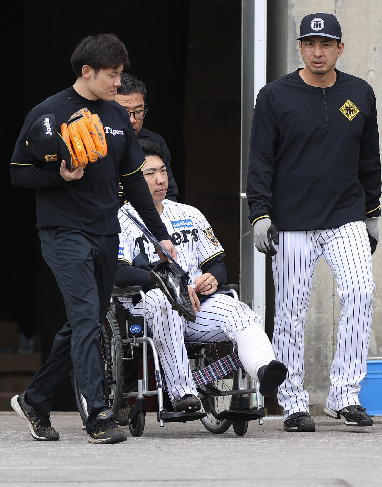 車椅子で運ばれる阪神石井（撮影・上山淳一）