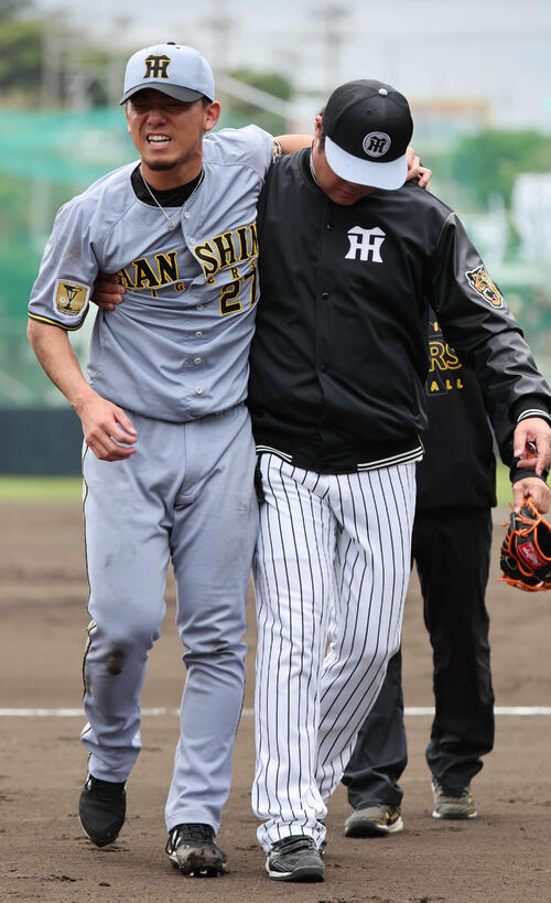 阪神紅白戦　1回裏白組2死一塁、佐藤の打球が当たった伊藤将司は苦悶の表情でグラウンドをあとにする（撮影・西尾就之）