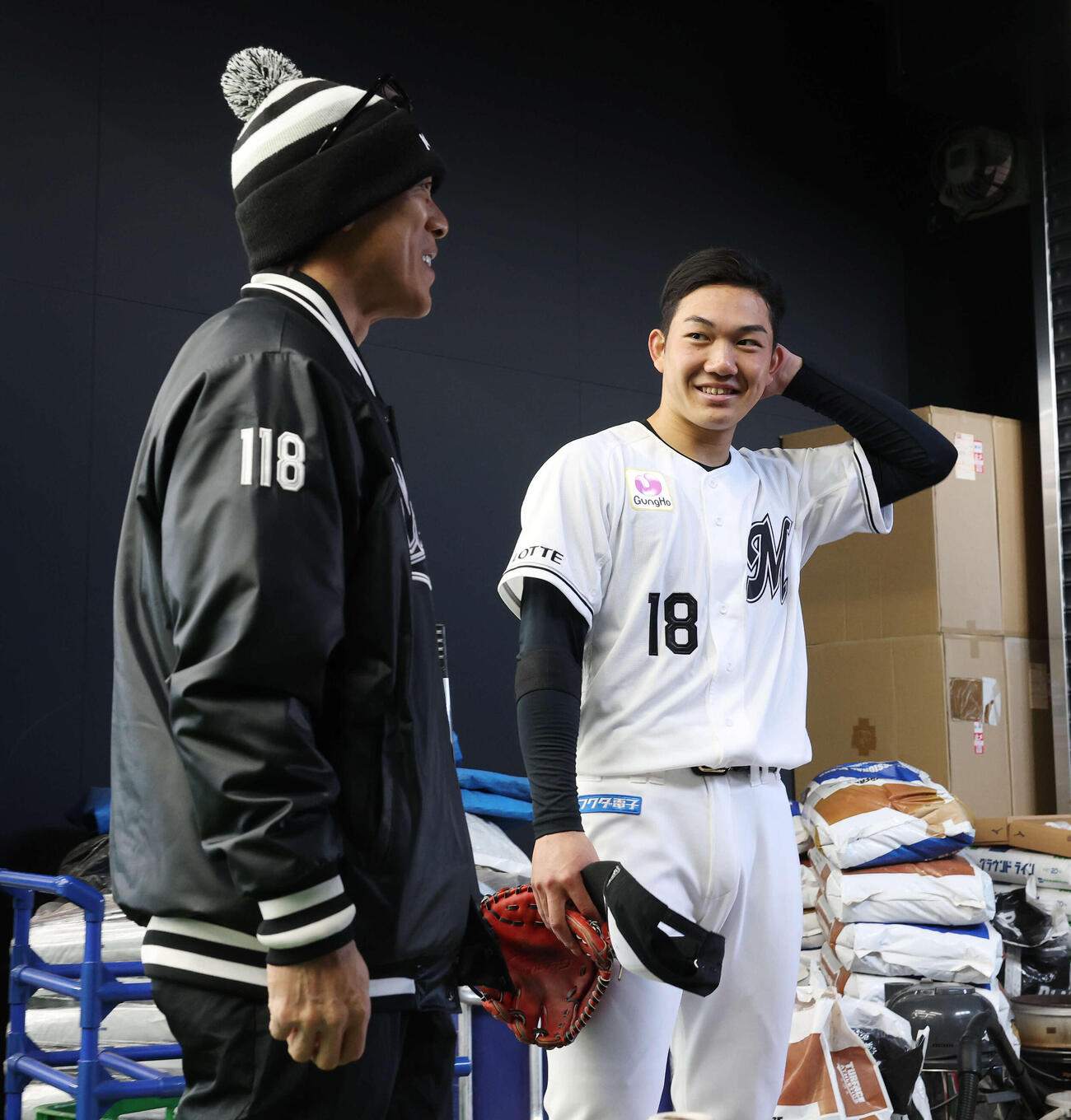 ブルペンでの投球を終えロッテ松井臨時コーチ（左）と笑顔で言葉を交わす石垣元（撮影・宮地輝）