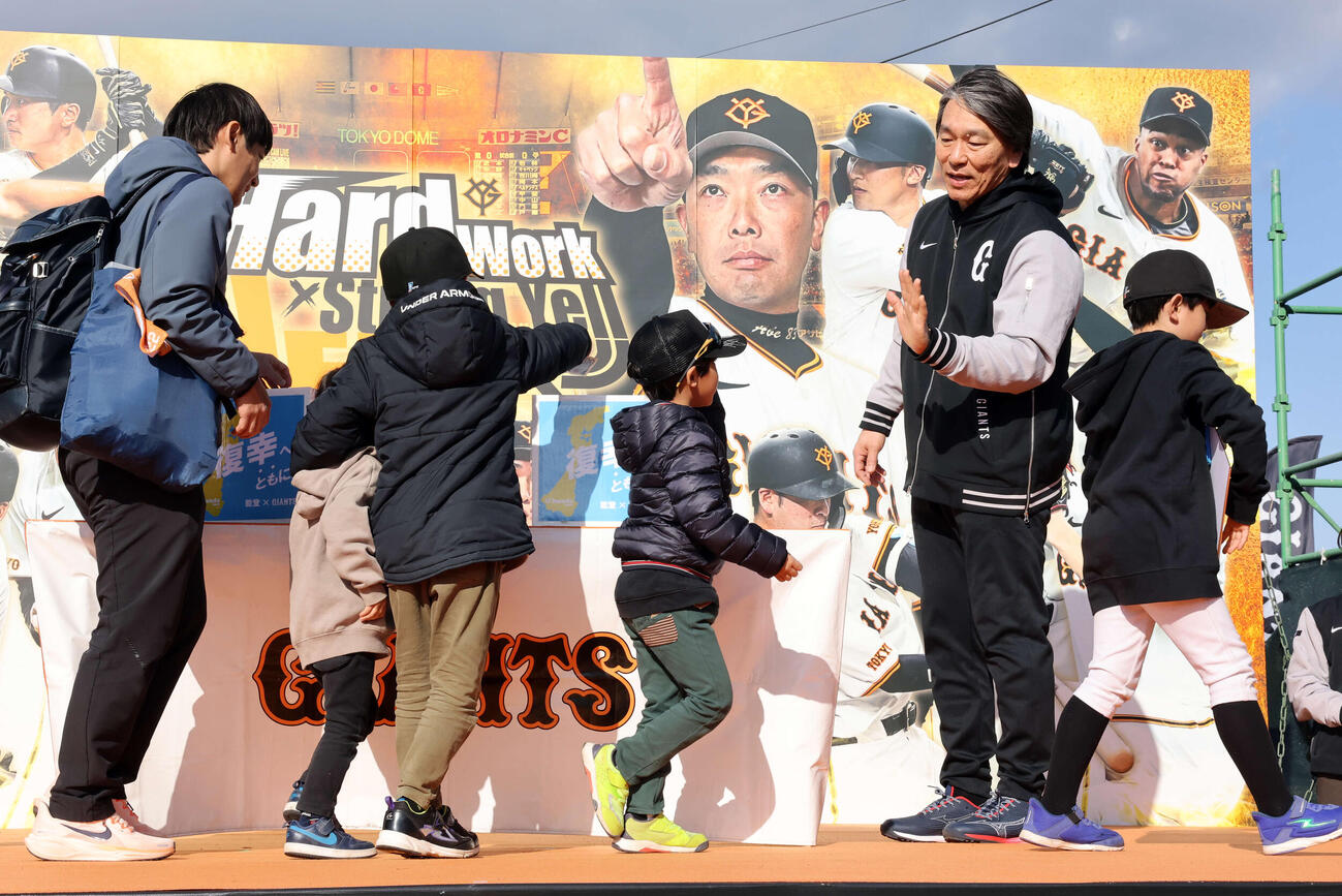 練習後、能登復興募金を募り、ファンの少年たちとハイタッチする巨人松井臨時コーチ（撮影・浅見桂子）