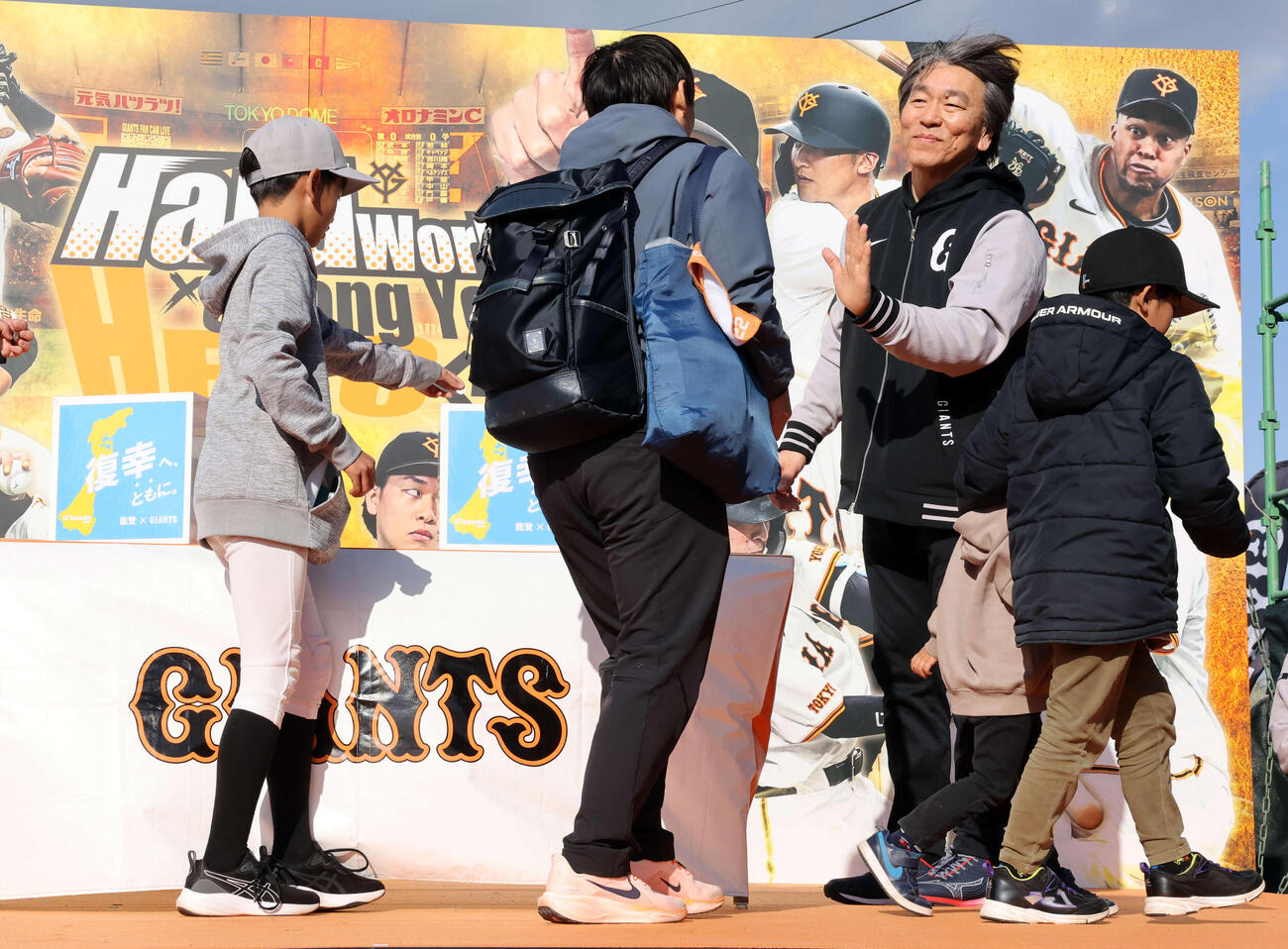練習後、能登復興募金を募り、ファンの少年たちとハイタッチする巨人松井臨時コーチ（撮影・浅見桂子）