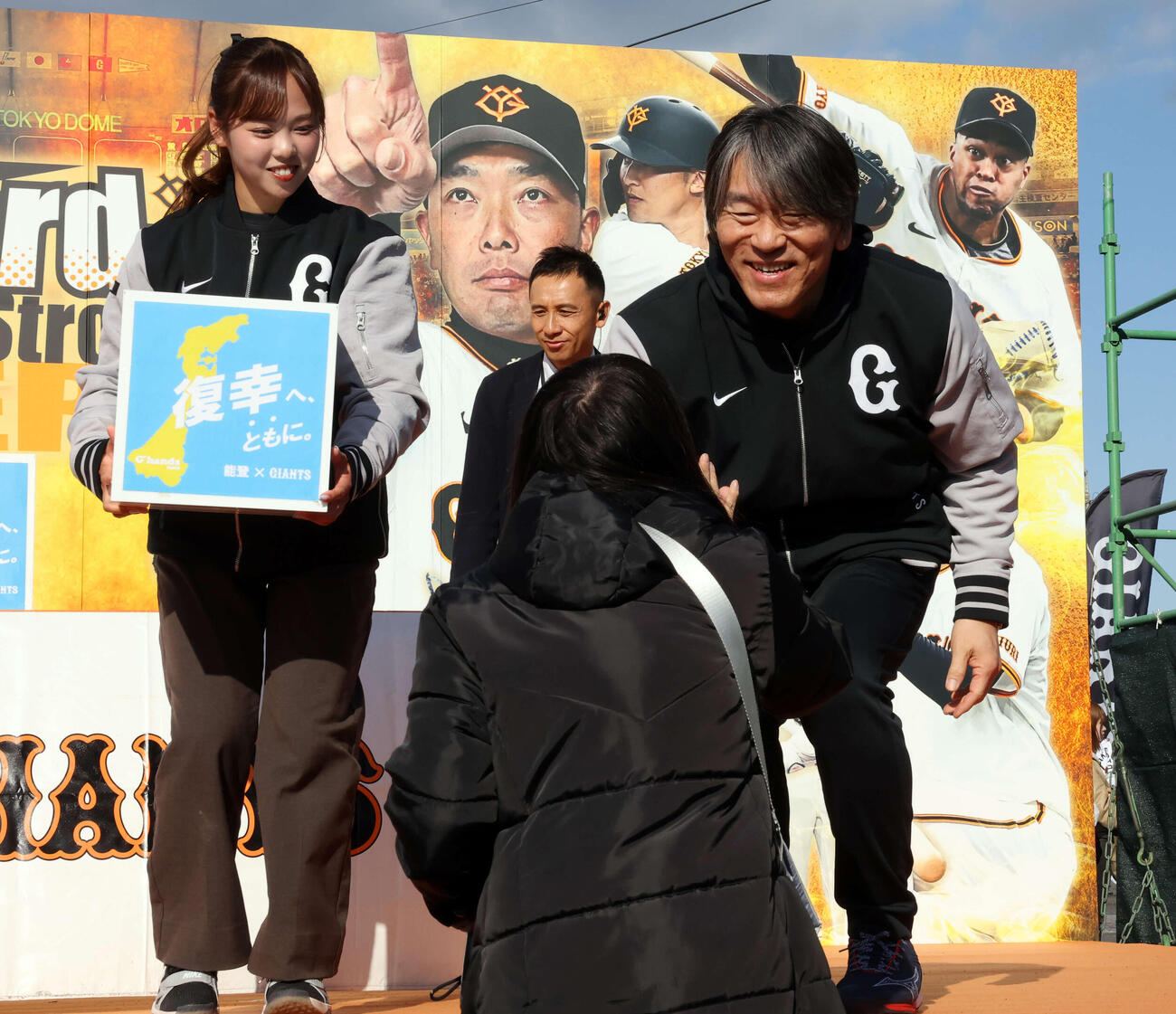 練習後、能登復興募金を募り、ファンとハイタッチする巨人松井臨時コーチ（撮影・浅見桂子）