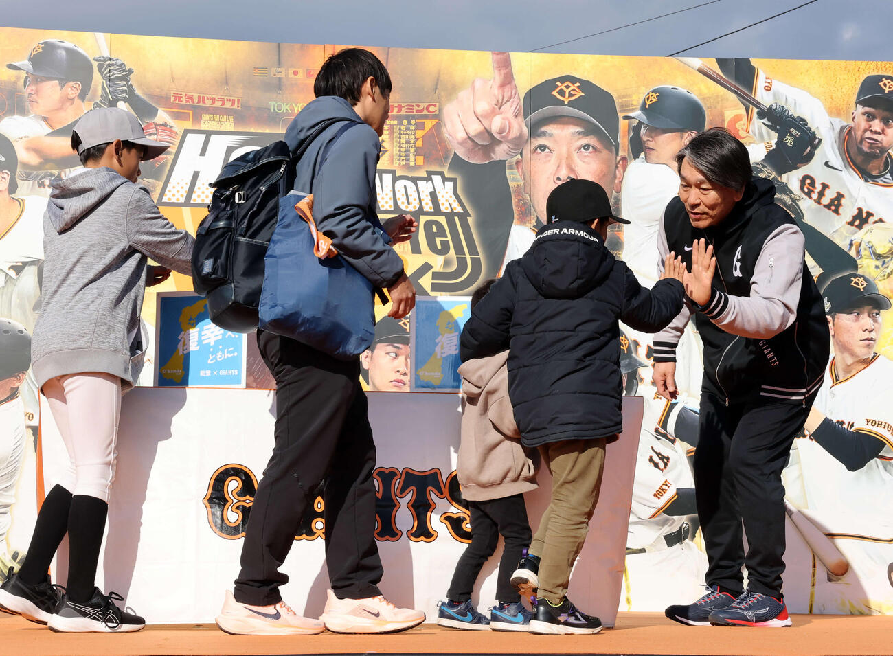 練習後、能登復興募金を募り、ファンの少年たちとハイタッチする巨人松井臨時コーチ（撮影・浅見桂子）