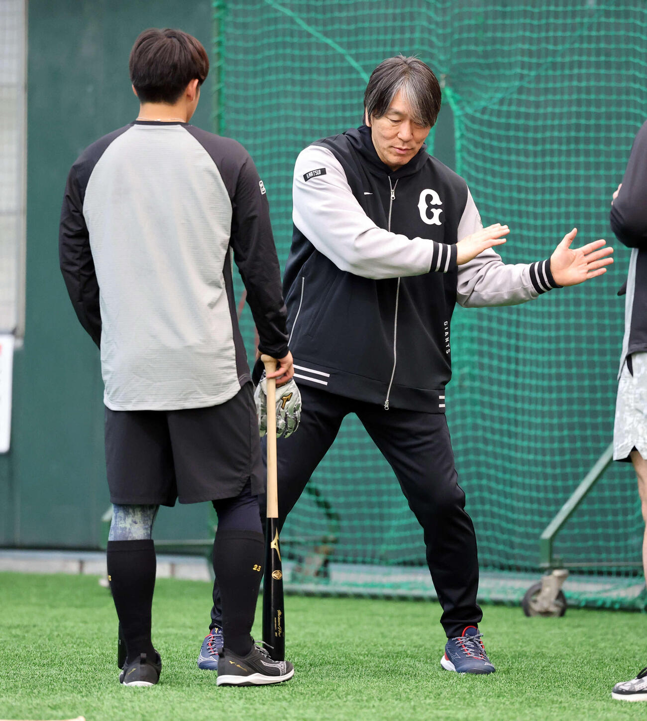 巨人石塚（左）を身ぶり手ぶりで指導する松井臨時コーチ（撮影・浅見桂子）