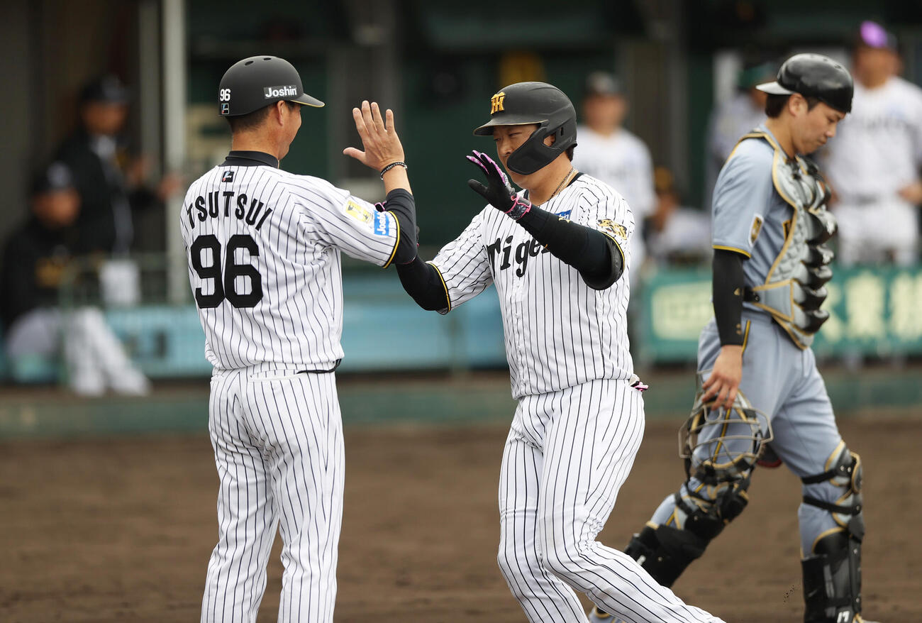 阪神紅白戦　2回裏白組無死、大山（中央）は左越え本塁打を放ち筒井外野守備兼走塁チーフコーチとハイタッチする。右は捕手伏見（撮影・上山淳一）
