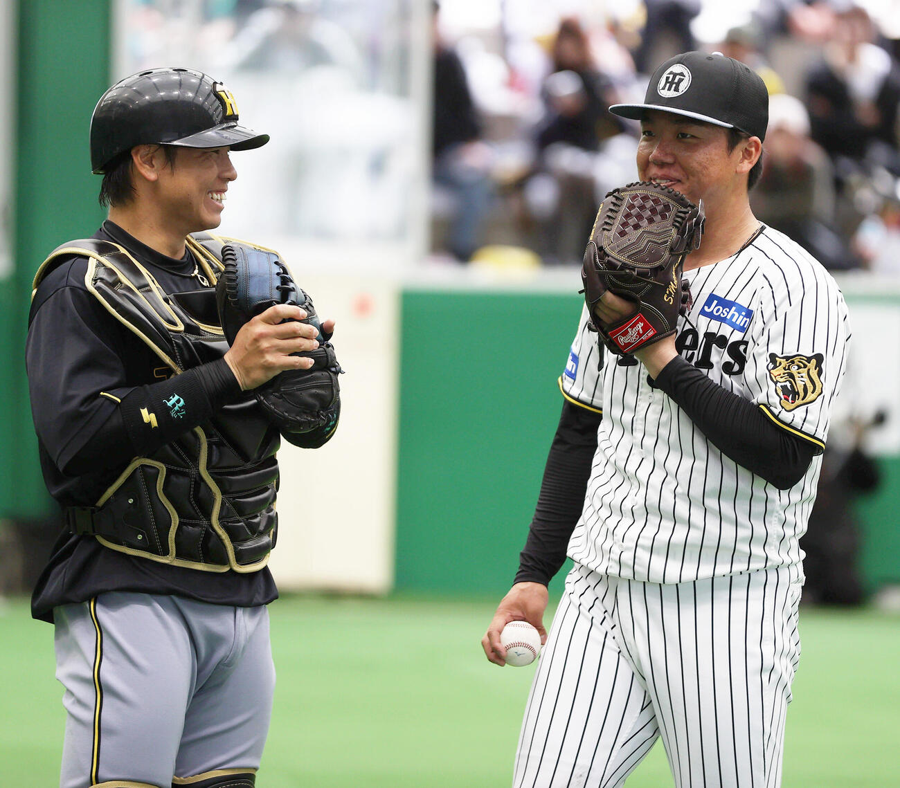 ブルペンで投球を終えた阪神村上（右）は捕手梅野と笑顔で話す（撮影・上山淳一）