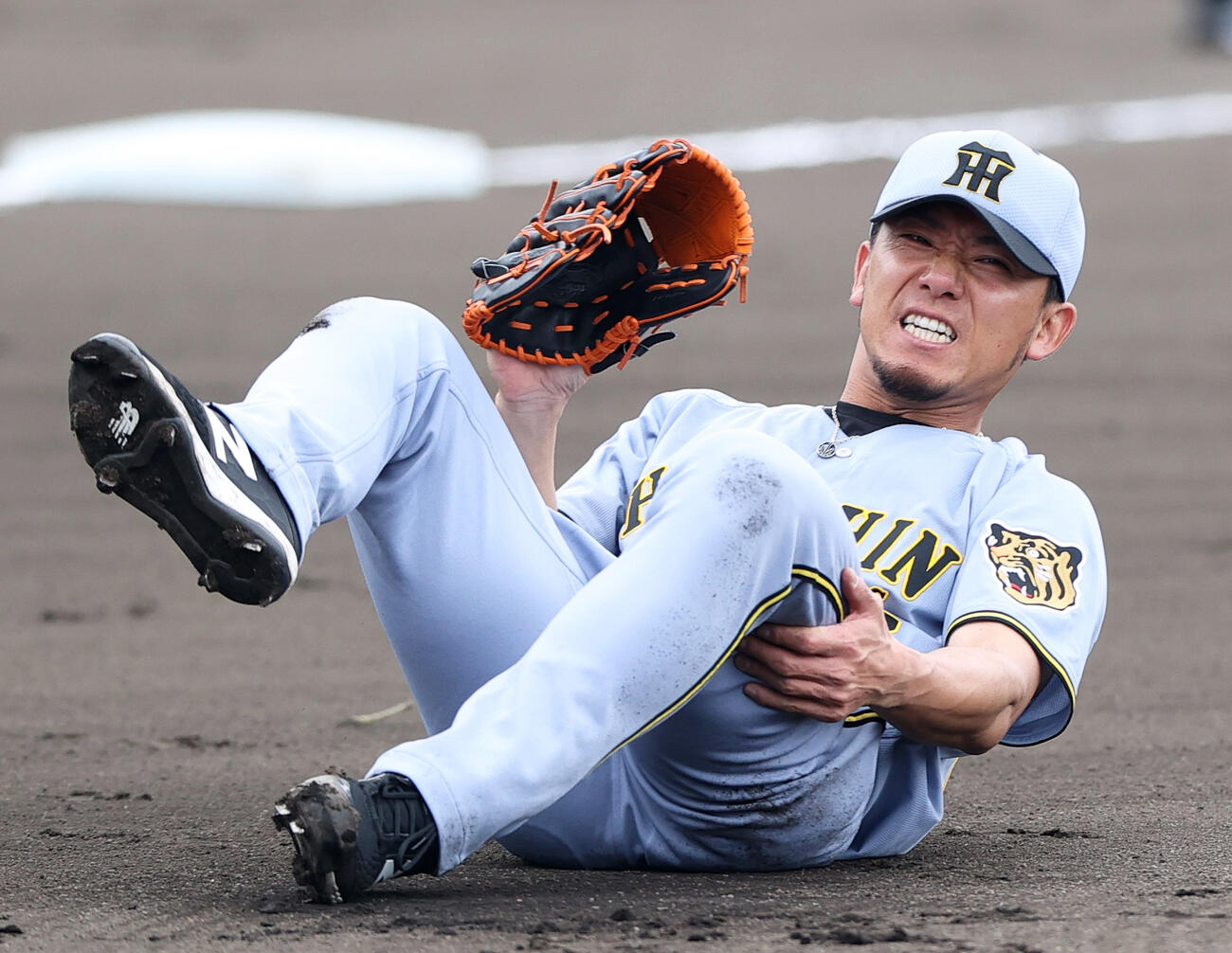 打球が当たり倒れ込む阪神伊藤将司（2026年2月撮影）